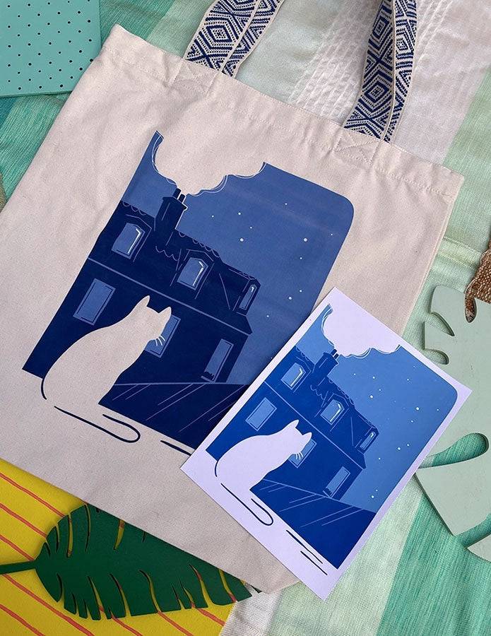 Grand totebag fabriqué en matières recyclées et imprimé en France représentant un paysage nocturne paisible. Ambiance calme d'une ville de nuit, avec un chat qui regarde les toits.